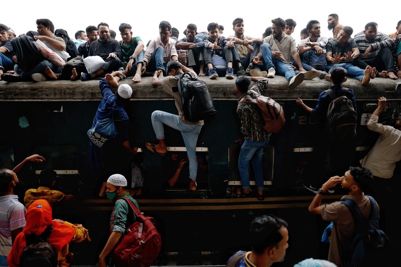 Orang-orang memanjat atap kereta api saat meninggalkan Dhaka untuk merayakan Idul Fitri, yang menandai berakhirnya bulan suci Ramadhan bagi umat Muslim, bersama keluarga mereka, di Stasiun Kereta Api Tongi di Gazipur, Bangladesh, 18 Maret 2026. REUTERS/Mohammad Ponir Hossain