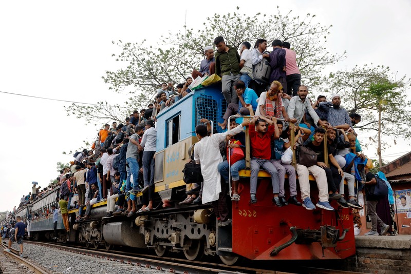Orang-orang memanjat atap kereta api saat meninggalkan Dhaka untuk merayakan Idul Fitri, yang menandai berakhirnya bulan suci Ramadhan bagi umat Muslim, bersama keluarga mereka, di Stasiun Kereta Api Tongi di Gazipur, Bangladesh, 18 Maret 2026. REUTERS/Mohammad Ponir Hossain