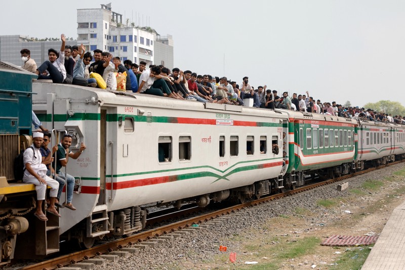 Orang-orang memanjat atap kereta api saat meninggalkan Dhaka untuk merayakan Idul Fitri, yang menandai berakhirnya bulan suci Ramadhan bagi umat Muslim, bersama keluarga mereka, di Stasiun Kereta Api Tongi di Gazipur, Bangladesh, 18 Maret 2026. REUTERS/Mohammad Ponir Hossain