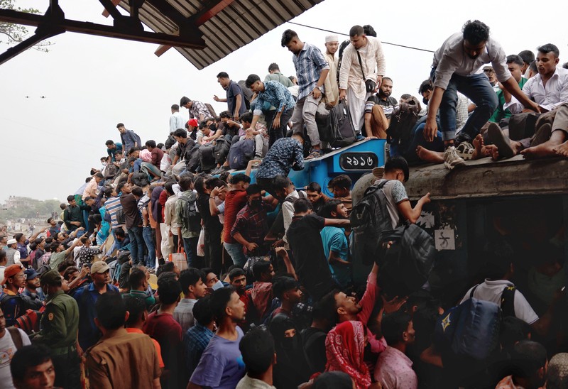 Orang-orang memanjat atap kereta api saat meninggalkan Dhaka untuk merayakan Idul Fitri, yang menandai berakhirnya bulan suci Ramadhan bagi umat Muslim, bersama keluarga mereka, di Stasiun Kereta Api Tongi di Gazipur, Bangladesh, 18 Maret 2026. REUTERS/Mohammad Ponir Hossain