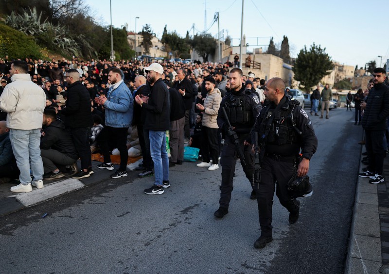 Para jamaah Muslim Palestina berdoa di tepi jalan untuk menandai berakhirnya bulan puasa suci Ramadan, karena mereka tidak diizinkan untuk menghadiri salat Idul Fitri di kompleks Al-Aqsa, yang juga dikenal oleh orang Yahudi sebagai Bukit Bait Suci, menyusul pembatasan berkumpul dalam kelompok besar, di tengah konflik AS-Israel dengan Iran, di Yerusalem, 20 Maret 2026. (REUTERS/Ammar Awad)