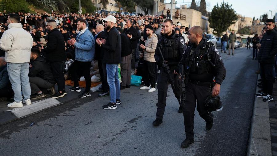 Para jamaah Muslim Palestina berdoa di tepi jalan untuk menandai berakhirnya bulan puasa suci Ramadan, karena mereka tidak diizinkan untuk menghadiri salat Idul Fitri di kompleks Al-Aqsa, yang juga dikenal oleh orang Yahudi sebagai Bukit Bait Suci, menyusul pembatasan berkumpul dalam kelompok besar, di tengah konflik AS-Israel dengan Iran, di Yerusalem, 20 Maret 2026. (REUTERS/Ammar Awad)