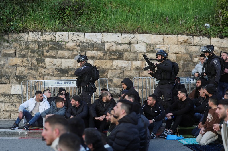 Para jamaah Muslim Palestina berdoa di tepi jalan untuk menandai berakhirnya bulan puasa suci Ramadan, karena mereka tidak diizinkan untuk menghadiri salat Idul Fitri di kompleks Al-Aqsa, yang juga dikenal oleh orang Yahudi sebagai Bukit Bait Suci, menyusul pembatasan berkumpul dalam kelompok besar, di tengah konflik AS-Israel dengan Iran, di Yerusalem, 20 Maret 2026. (REUTERS/Ammar Awad)