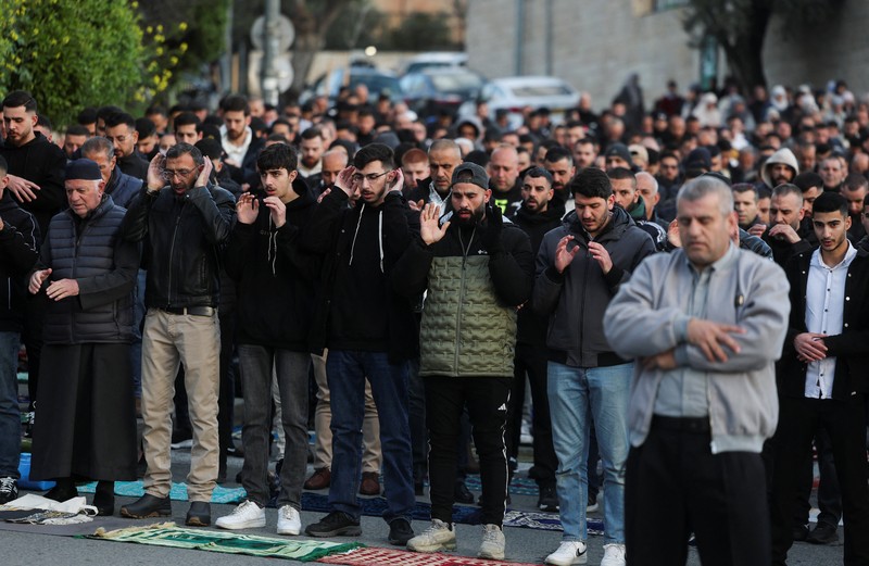 Para jamaah Muslim Palestina berdoa di tepi jalan untuk menandai berakhirnya bulan puasa suci Ramadan, karena mereka tidak diizinkan untuk menghadiri salat Idul Fitri di kompleks Al-Aqsa, yang juga dikenal oleh orang Yahudi sebagai Bukit Bait Suci, menyusul pembatasan berkumpul dalam kelompok besar, di tengah konflik AS-Israel dengan Iran, di Yerusalem, 20 Maret 2026. (REUTERS/Ammar Awad)