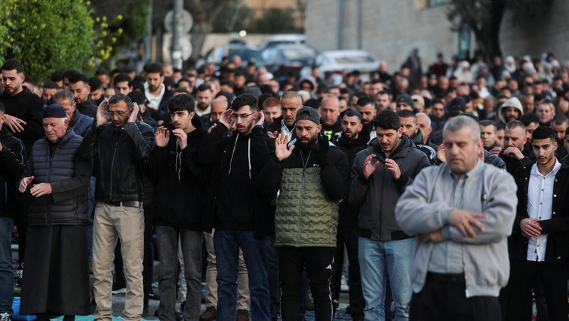 Para jamaah Muslim Palestina berdoa di tepi jalan untuk menandai berakhirnya bulan puasa suci Ramadan, karena mereka tidak diizinkan untuk menghadiri salat Idul Fitri di kompleks Al-Aqsa, yang juga dikenal oleh orang Yahudi sebagai Bukit Bait Suci, menyusul pembatasan berkumpul dalam kelompok besar, di tengah konflik AS-Israel dengan Iran, di Yerusalem, 20 Maret 2026. (REUTERS/Ammar Awad)