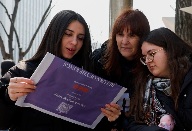 Para penggemar grup Kpop BTS bersorak menjelang konser 'BTS The Comeback Live Arirang' saat mereka menunggu di dekat lokasi konser, di pusat kota Seoul, Korea Selatan, 21 Maret 2026. (REUTERS/Kim Hong-ji)