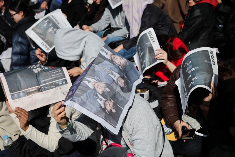 Para penggemar grup Kpop BTS bersorak menjelang konser 'BTS The Comeback Live Arirang' saat mereka menunggu di dekat lokasi konser, di pusat kota Seoul, Korea Selatan, 21 Maret 2026. (REUTERS/Kim Hong-ji)