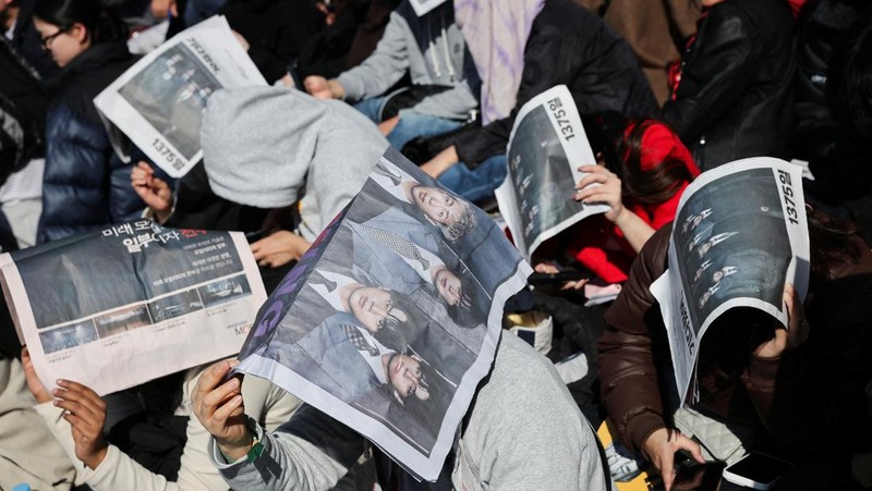 Para penggemar grup Kpop BTS bersorak menjelang konser 'BTS The Comeback Live Arirang' saat mereka menunggu di dekat lokasi konser, di pusat kota Seoul, Korea Selatan, 21 Maret 2026. (REUTERS/Kim Hong-ji)