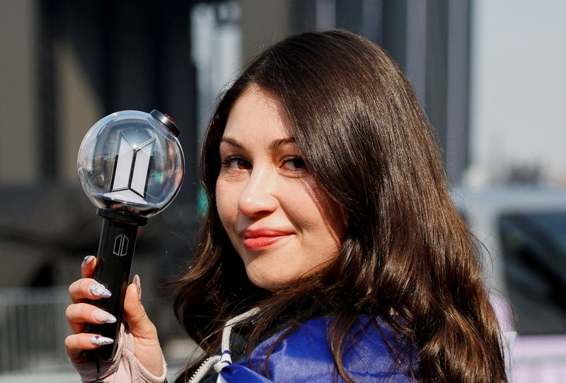 Para penggemar grup Kpop BTS bersorak menjelang konser 'BTS The Comeback Live Arirang' saat mereka menunggu di dekat lokasi konser, di pusat kota Seoul, Korea Selatan, 21 Maret 2026. (REUTERS/Kim Hong-ji)