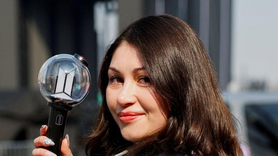 Para penggemar grup Kpop BTS bersorak menjelang konser 'BTS The Comeback Live Arirang' saat mereka menunggu di dekat lokasi konser, di pusat kota Seoul, Korea Selatan, 21 Maret 2026. (REUTERS/Kim Hong-ji)