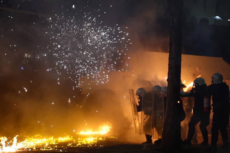 Para petugas polisi bereaksi terhadap bom molotov selama protes anti-pemerintah, yang dipicu oleh penyelidikan korupsi terhadap pejabat tinggi pemerintah, di Tirana, Albania, 22 Maret 2026. (REUTERS/Florion Goga)