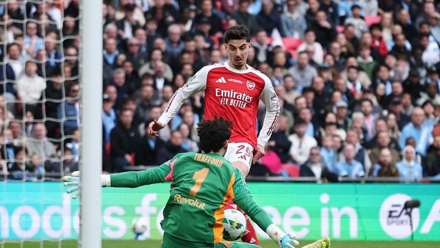 Para pemain Manchester City, termasuk Erling Haaland, Ruben Dias, dan Rodri, merayakan kemenangan dengan mengangkat trofi Piala Carabao di podium setelah final melawan Arsenal di Stadion Wembley, London, Inggris, 22 Maret 2026. (Action Images via Reuters/Paul Childs)