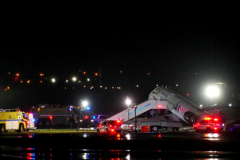 Tim penyelamat bekerja di sekitar pesawat Air Canada Express dan kendaraan darat yang bertabrakan di Bandara LaGuardia di Queens, New York, AS, 23 Maret 2026. (REUTERS/Bing Guan)
