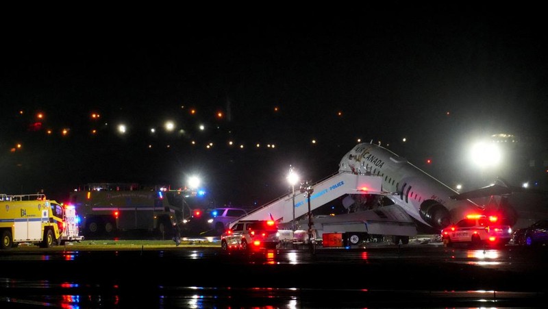 Tim penyelamat bekerja di sekitar pesawat Air Canada Express dan kendaraan darat yang bertabrakan di Bandara LaGuardia di Queens, New York, AS, 23 Maret 2026. (REUTERS/Bing Guan)