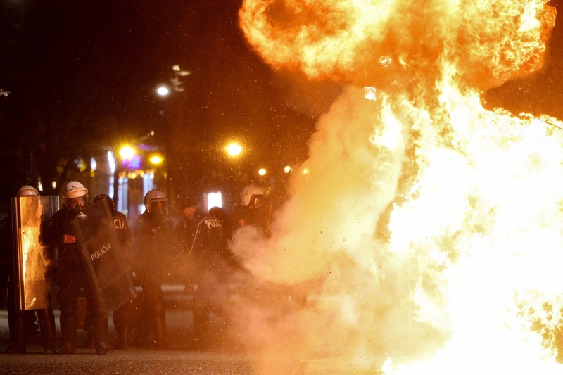Para petugas polisi bereaksi terhadap bom molotov selama protes anti-pemerintah, yang dipicu oleh penyelidikan korupsi terhadap pejabat tinggi pemerintah, di Tirana, Albania, 22 Maret 2026. (REUTERS/Florion Goga)