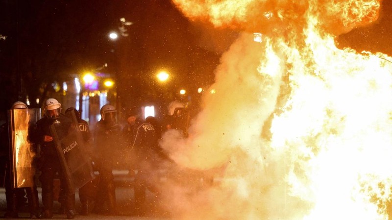Para petugas polisi bereaksi terhadap bom molotov selama protes anti-pemerintah, yang dipicu oleh penyelidikan korupsi terhadap pejabat tinggi pemerintah, di Tirana, Albania, 22 Maret 2026. (REUTERS/Florion Goga)