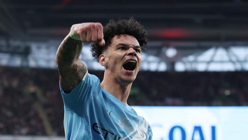 Para pemain Manchester City, termasuk Erling Haaland, Ruben Dias, dan Rodri, merayakan kemenangan dengan mengangkat trofi Piala Carabao di podium setelah final melawan Arsenal di Stadion Wembley, London, Inggris, 22 Maret 2026. (Action Images via Reuters/Paul Childs)
