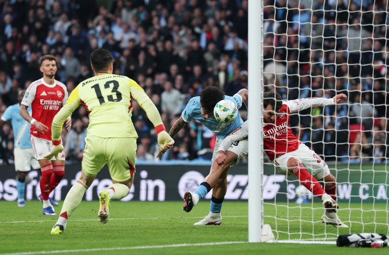 Para pemain Manchester City, termasuk Erling Haaland, Ruben Dias, dan Rodri, merayakan kemenangan dengan mengangkat trofi Piala Carabao di podium setelah final melawan Arsenal di Stadion Wembley, London, Inggris, 22 Maret 2026. (Action Images via Reuters/Paul Childs)