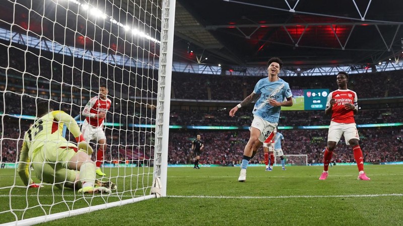 Para pemain Manchester City, termasuk Erling Haaland, Ruben Dias, dan Rodri, merayakan kemenangan dengan mengangkat trofi Piala Carabao di podium setelah final melawan Arsenal di Stadion Wembley, London, Inggris, 22 Maret 2026. (Action Images via Reuters/Paul Childs)