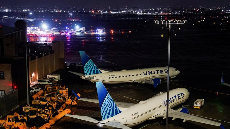Tim penyelamat bekerja di sekitar pesawat Air Canada Express dan kendaraan darat yang bertabrakan di Bandara LaGuardia di Queens, New York, AS, 23 Maret 2026. (REUTERS/Bing Guan)