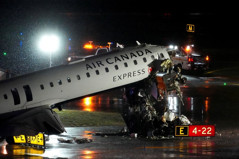 Tim penyelamat bekerja di sekitar pesawat Air Canada Express dan kendaraan darat yang bertabrakan di Bandara LaGuardia di Queens, New York, AS, 23 Maret 2026. (REUTERS/Bing Guan)