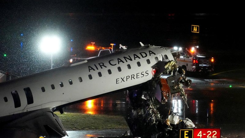 Tim penyelamat bekerja di sekitar pesawat Air Canada Express dan kendaraan darat yang bertabrakan di Bandara LaGuardia di Queens, New York, AS, 23 Maret 2026. (REUTERS/Bing Guan)