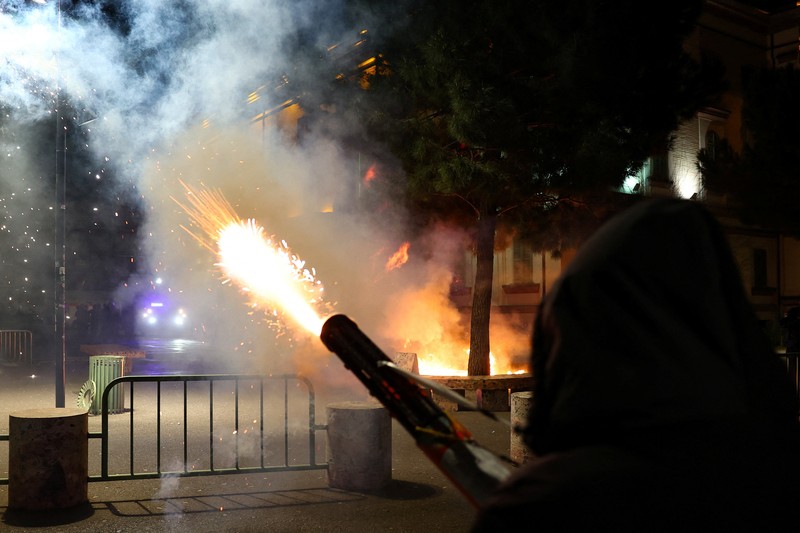 Para petugas polisi bereaksi terhadap bom molotov selama protes anti-pemerintah, yang dipicu oleh penyelidikan korupsi terhadap pejabat tinggi pemerintah, di Tirana, Albania, 22 Maret 2026. (REUTERS/Florion Goga)