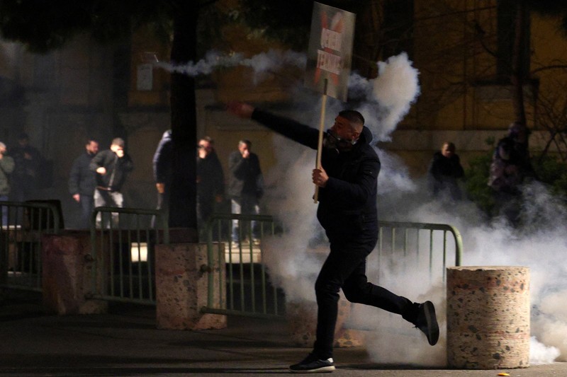 Para petugas polisi bereaksi terhadap bom molotov selama protes anti-pemerintah, yang dipicu oleh penyelidikan korupsi terhadap pejabat tinggi pemerintah, di Tirana, Albania, 22 Maret 2026. (REUTERS/Florion Goga)