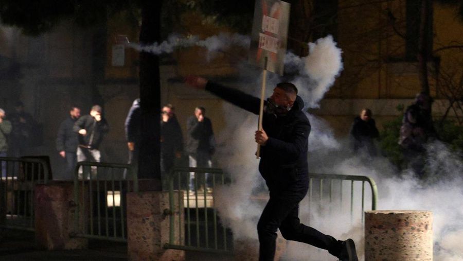Para petugas polisi bereaksi terhadap bom molotov selama protes anti-pemerintah, yang dipicu oleh penyelidikan korupsi terhadap pejabat tinggi pemerintah, di Tirana, Albania, 22 Maret 2026. (REUTERS/Florion Goga)