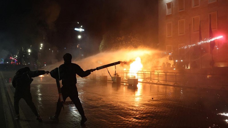 Para petugas polisi bereaksi terhadap bom molotov selama protes anti-pemerintah, yang dipicu oleh penyelidikan korupsi terhadap pejabat tinggi pemerintah, di Tirana, Albania, 22 Maret 2026. (REUTERS/Florion Goga)