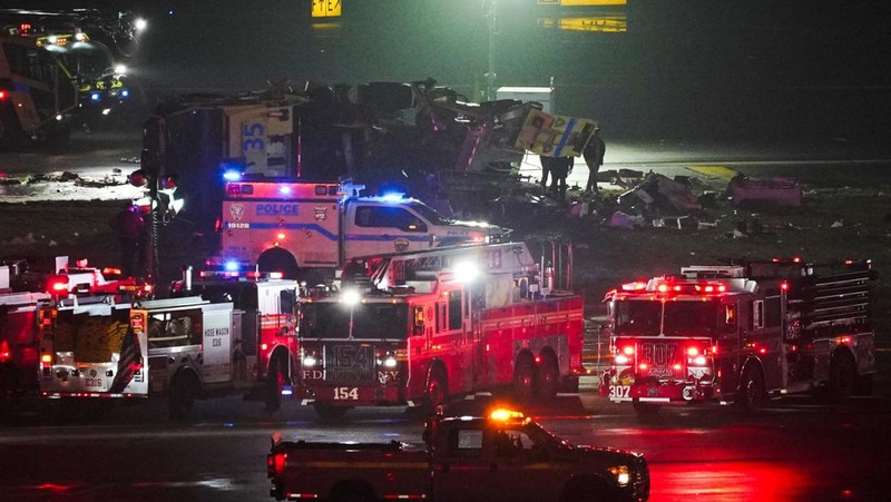 Tim penyelamat bekerja di sekitar pesawat Air Canada Express dan kendaraan darat yang bertabrakan di Bandara LaGuardia di Queens, New York, AS, 23 Maret 2026. (REUTERS/Bing Guan)