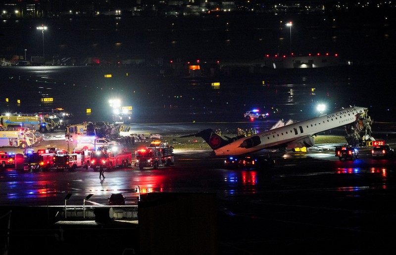 Tim penyelamat bekerja di sekitar pesawat Air Canada Express dan kendaraan darat yang bertabrakan di Bandara LaGuardia di Queens, New York, AS, 23 Maret 2026. (REUTERS/Bing Guan)