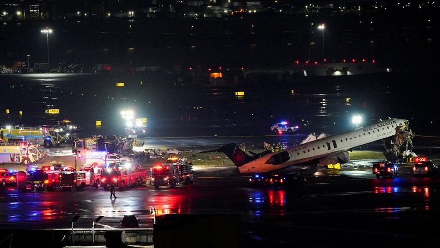 Tim penyelamat bekerja di sekitar pesawat Air Canada Express dan kendaraan darat yang bertabrakan di Bandara LaGuardia di Queens, New York, AS, 23 Maret 2026. (REUTERS/Bing Guan)