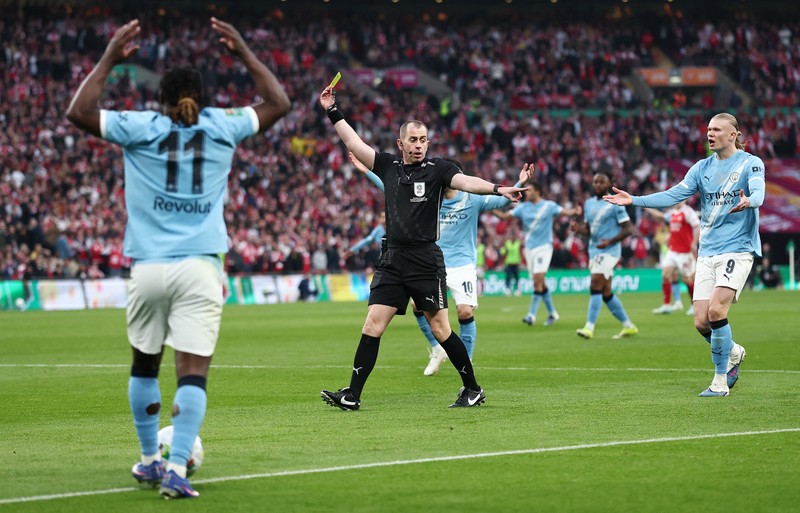 Para pemain Manchester City, termasuk Erling Haaland, Ruben Dias, dan Rodri, merayakan kemenangan dengan mengangkat trofi Piala Carabao di podium setelah final melawan Arsenal di Stadion Wembley, London, Inggris, 22 Maret 2026. (Action Images via Reuters/Paul Childs)