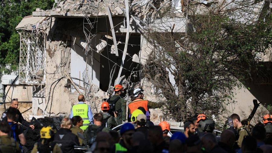 Anggota tim penyelamat bekerja di samping bangunan yang hancur di lokasi kejadian setelah serangan rudal Iran di Israel tengah, di tengah konflik AS-Israel dengan Iran, di Tel Aviv, Israel, Selasa (24/3/2026). (REUTERS/Tomer Appelbaum)