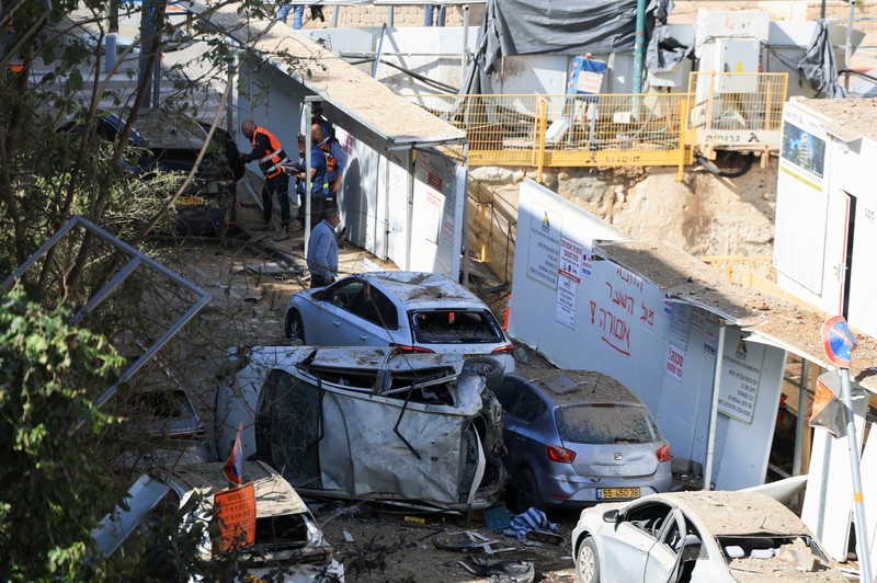 Anggota tim penyelamat bekerja di samping bangunan yang hancur di lokasi kejadian setelah serangan rudal Iran di Israel tengah, di tengah konflik AS-Israel dengan Iran, di Tel Aviv, Israel, Selasa (24/3/2026). (REUTERS/Tomer Appelbaum)