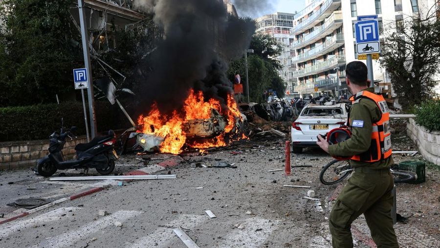 Anggota tim penyelamat bekerja di samping bangunan yang hancur di lokasi kejadian setelah serangan rudal Iran di Israel tengah, di tengah konflik AS-Israel dengan Iran, di Tel Aviv, Israel, Selasa (24/3/2026). (REUTERS/Tomer Appelbaum)
