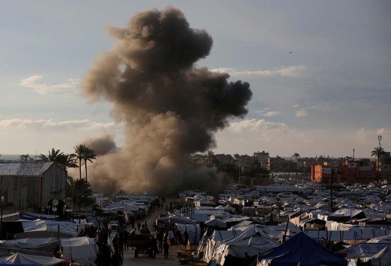 Smoke and flames rise following an Israeli strike near a tent camp sheltering displaced Palestinians in Deir al-Balah, central Gaza Strip, March 25, 2026. The Israeli military ordered camp to evacuate before the strike, according to residents. REUTERS/Stringer