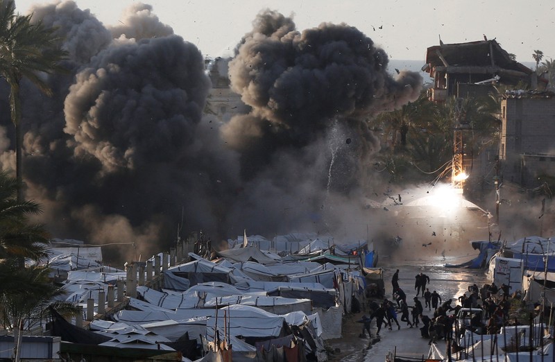 Smoke and flames rise following an Israeli strike near a tent camp sheltering displaced Palestinians in Deir al-Balah, central Gaza Strip, March 25, 2026. The Israeli military ordered camp to evacuate before the strike, according to residents. REUTERS/Stringer