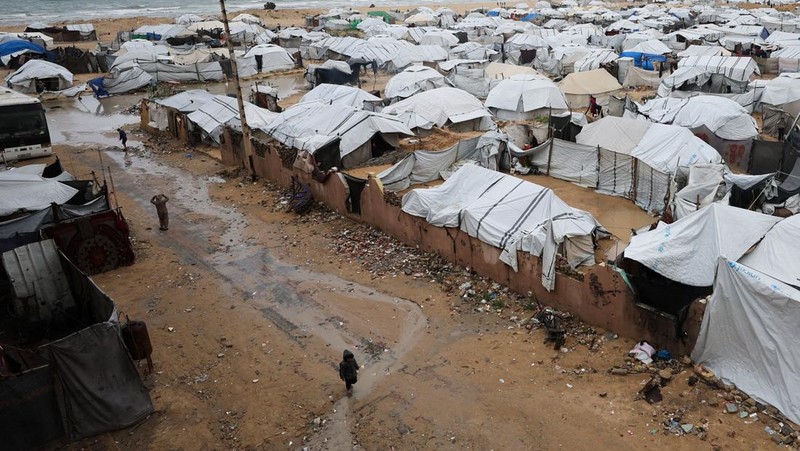 Para pengungsi Palestina berlindung di sebuah kamp tenda pada hari hujan di Kota Gaza, 26 Maret 2026. (REUTERS/Dawoud Abu Alkas)