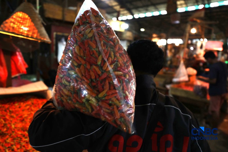 Pekerja melakukan bongkar muat cabai rawit merah di Pasar Kramat Jati, Jakarta, Kamis (26/3/2026). (CNBC Indonesia/Tri Susilo)