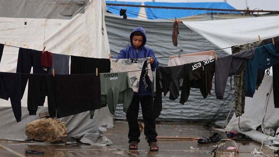 Para pengungsi Palestina berlindung di sebuah kamp tenda pada hari hujan di Kota Gaza, 26 Maret 2026. (REUTERS/Dawoud Abu Alkas)