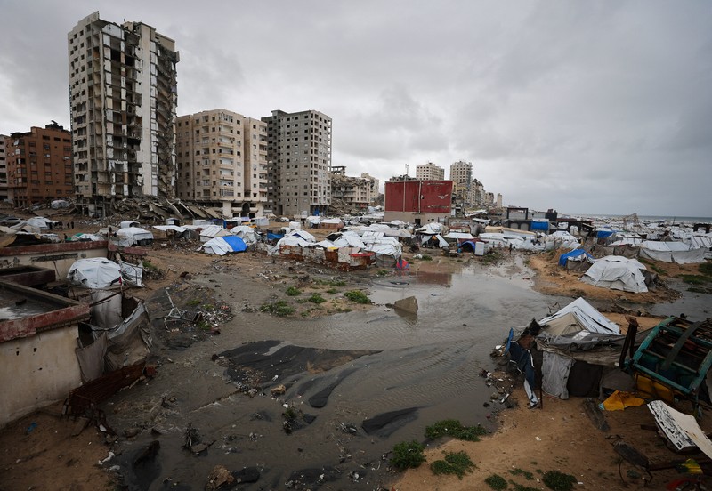 Para pengungsi Palestina berlindung di sebuah kamp tenda pada hari hujan di Kota Gaza, 26 Maret 2026. (REUTERS/Dawoud Abu Alkas)
