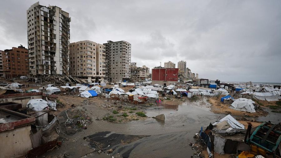 Para pengungsi Palestina berlindung di sebuah kamp tenda pada hari hujan di Kota Gaza, 26 Maret 2026. (REUTERS/Dawoud Abu Alkas)