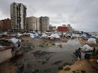 Seorang pemuda Palestina yang mengungsi berlindung di sebuah kamp tenda pada hari hujan di Kota Gaza, 26 Maret 2026. *(REUTERS/Dawoud Abu Alkas)
