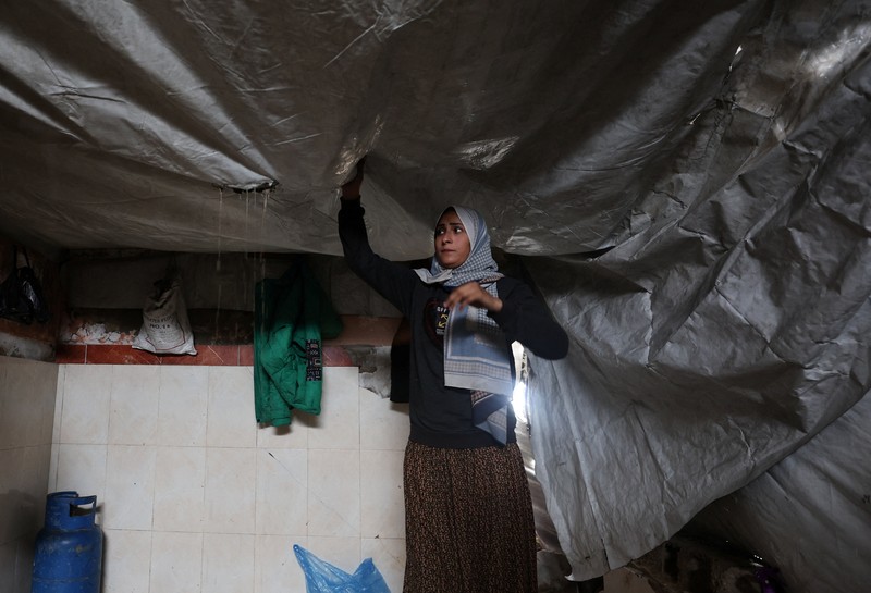 Para pengungsi Palestina berlindung di sebuah kamp tenda pada hari hujan di Kota Gaza, 26 Maret 2026. (REUTERS/Dawoud Abu Alkas)