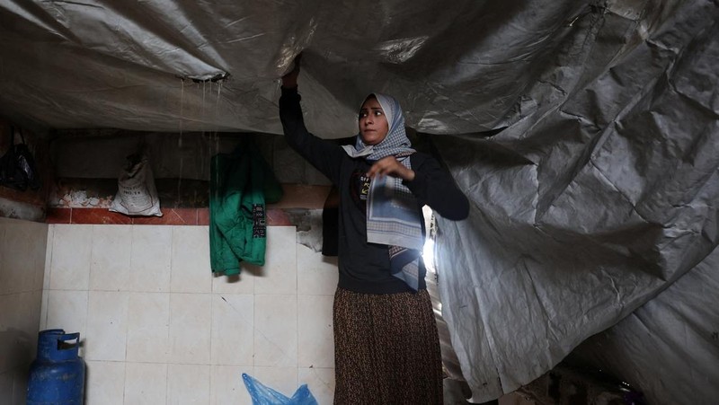 Para pengungsi Palestina berlindung di sebuah kamp tenda pada hari hujan di Kota Gaza, 26 Maret 2026. (REUTERS/Dawoud Abu Alkas)