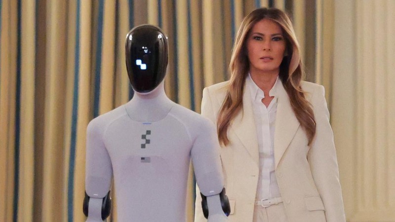 U.S. first lady Melania Trump walks next to a humanoid robot as she hosts a roundtable event on the second day of the inaugural Fostering the Future Together Global Coalition Summit, at the White House in Washington, D.C., U.S., March 25, 2026. REUTERS/Kylie Cooper      TPX IMAGES OF THE DAY
