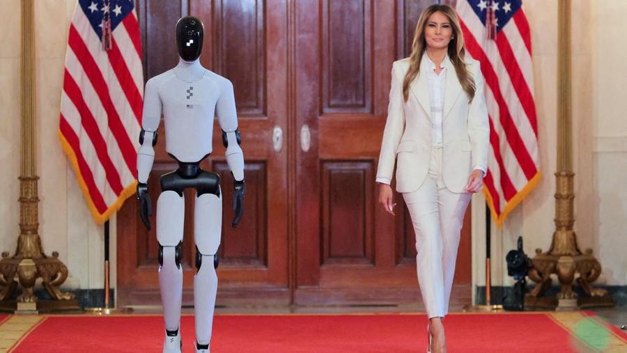 U.S. first lady Melania Trump walks next to a humanoid robot as she hosts a roundtable event on the second day of the inaugural Fostering the Future Together Global Coalition Summit, at the White House in Washington, D.C., U.S., March 25, 2026. REUTERS/Kylie Cooper      TPX IMAGES OF THE DAY