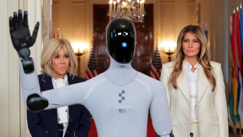 U.S. first lady Melania Trump walks next to a humanoid robot as she hosts a roundtable event on the second day of the inaugural Fostering the Future Together Global Coalition Summit, at the White House in Washington, D.C., U.S., March 25, 2026. REUTERS/Kylie Cooper      TPX IMAGES OF THE DAY